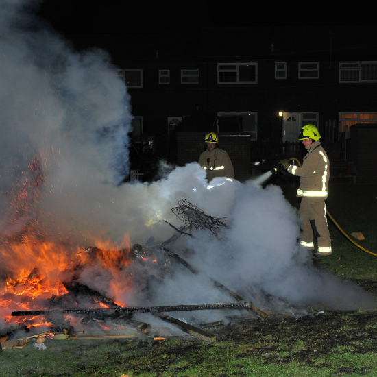 Firefighters attending to out of control bonfire
