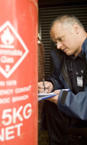 Inspection officer looking at a gas cannister. 
