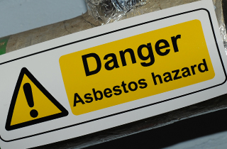 Danger sign reading 'Asbestos Hazard'.