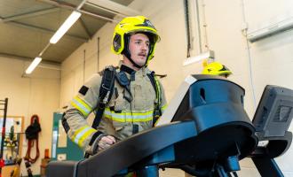 A firefighter, in full BA kit, on a treadmill