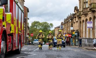 Three firefighters running outside Morley Town Hall
