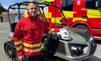 Mick Rhodes in wildfire fire kit standing next to an ArgoCat