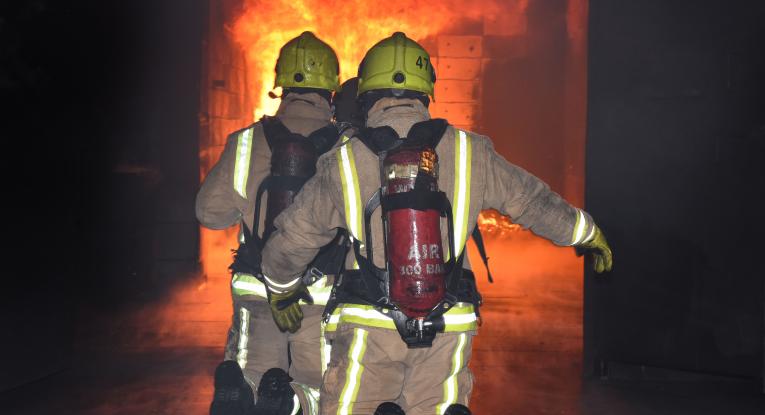 Firefighters tackling a fire in a container. 