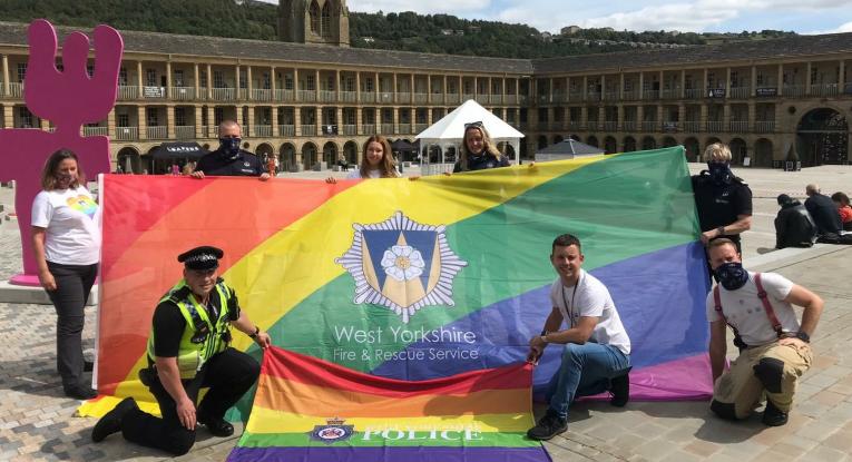Photograph of WYFRS staff with the PRIDE flag at the Piece Hall, Halifax.