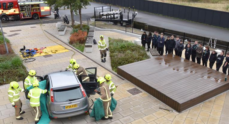Photograph of students of Kirklees College watching a road traffic accident demonstration during road safety week 2021.