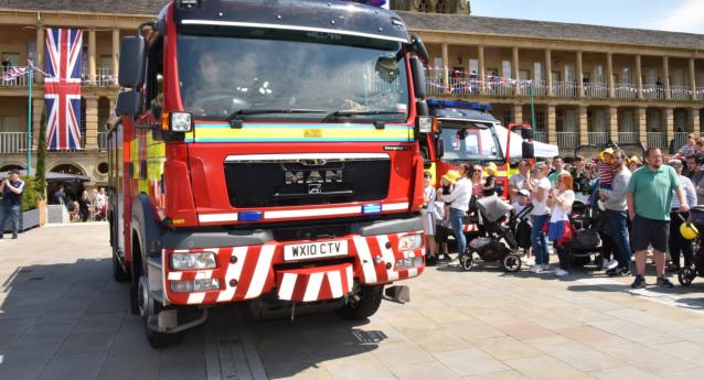 Fire engine inside piece hall, in front of union jack flag with public stood at the right hand side